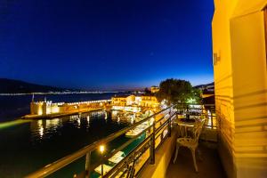 a balcony with a view of the water at night at Vip Lepanto Port Suites in Nafpaktos