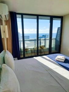 a bedroom with a large bed and a large window at Orbi City in Batumi in Batumi