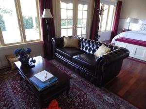 a living room with a leather couch and a coffee table at The Retreat at Amryhouse in Ashbourne