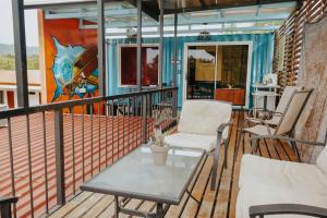 a balcony with chairs and a table and a mural at Wanderlust in Jacó