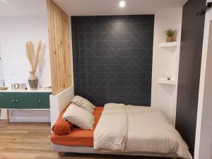 a bedroom with a bed with a black wall at Appartement - Narbonne in Narbonne