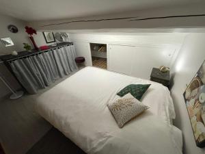 1 dormitorio con cama blanca y almohada en front de mer plage de la Nartelle sainte maxime FRANCE ****, en Sainte-Maxime