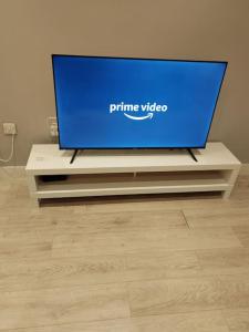 a large screen tv sitting on a tv stand at Central Huddersfield Apartment in Huddersfield