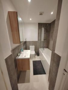 a bathroom with a sink and a toilet and a tub at Central Huddersfield Apartment in Huddersfield