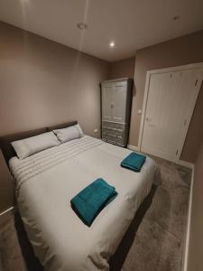 a bedroom with a large bed with two towels on it at Central Huddersfield Apartment in Huddersfield