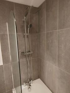 a shower with a shower head in a bathroom at Central Huddersfield Apartment in Huddersfield