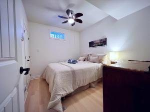 a bedroom with a bed and a ceiling fan at The Wonderland Cottage in Haliburton