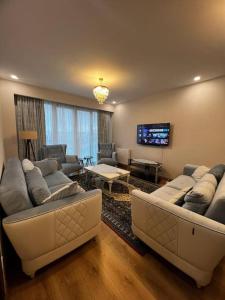 a living room with couches and a flat screen tv at Lux 2+1 apartment in Başakşehir ISTANBUL in Basaksehir