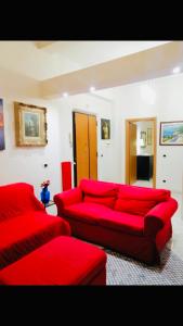 a living room with a red couch and red chairs at Casa Mirandola in Rome