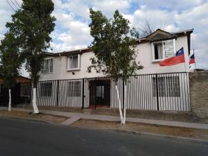 una casa con una bandera en una valla en MatSofy_Apartamento en Santiago