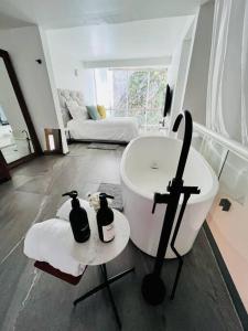 - Baño con bañera y 2 botellas en una mesa en Loft de estilo, moderno, amplio y súper cómodo., en Ciudad de México
