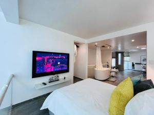 1 dormitorio con cama blanca y TV en la pared en Loft de estilo, moderno, amplio y súper cómodo., en Ciudad de México