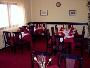 Hotel Čile في كولاسين: غرفة طعام مع طاولات وكراسي بمناديل حمراء