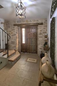 a living room with a wooden door and a chandelier at Apartamentos Turísticos El AOVE in Baeza