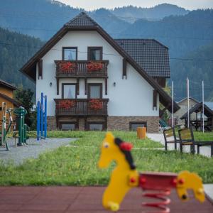 a toy horse on a playground in front of a house at Apartmány Pod Chopkom in Pavčina Lehota