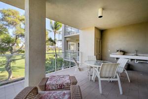 a patio with a table and chairs on a balcony at Waikoloa Village Condo with Pool and Golf Course Views in Waikoloa