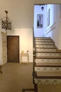 eine Treppe in einem Zimmer mit einem Tisch und einer Tür in der Unterkunft Apartamentos Turísticos El AOVE in Baeza