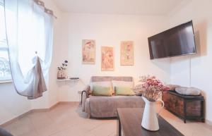 een woonkamer met een bank en een tv bij Casa Giovanetti in Grandola ed Uniti