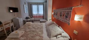 ein Schlafzimmer mit einem Bett und einer orangefarbenen Wand in der Unterkunft B&B Il Piccolo Giardino in Villasimius