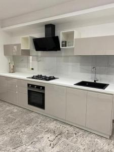 a white kitchen with a stove and a sink at La Baita Contemporanea; mix tra passato e presente in Prato