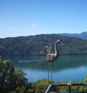 una estatua de un pájaro parado en el borde de un lago en Ferienwohnungen Klinar, en Millstatt