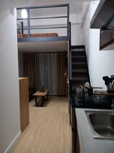 a small room with a bunk bed and a kitchen at Leon's Den in Baguio