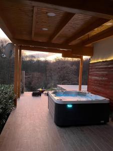a hot tub sitting on a patio under a roof at Crab's Creek Zagreb in Rakov Potok