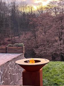 a fire pit sitting in a yard next to a stone wall at Crab's Creek Zagreb in Rakov Potok