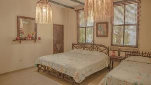 a bedroom with two beds and a mirror and windows at Hostería Ecológica El Faro in Salinas