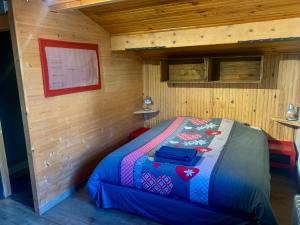 een slaapkamer met een bed in een houten hut bij Le Tremplin 61 in Barcelonnette