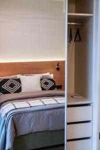 een slaapkamer met een bed met een spiegel ernaast bij AlMar- Διαμέρισμα στο κέντρο της Ηλιούπολης in Athene