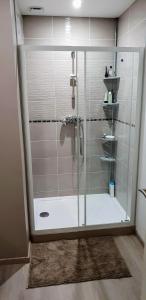 a shower with a glass door in a bathroom at Maison duplex de ville avec terrasse et clim in Foucherans