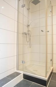La salle de bains est pourvue d'une douche avec une porte en verre. dans l'établissement Haus Kim Thinh, à Betzdorf