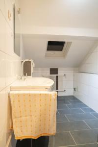 La salle de bains est pourvue d'un lavabo et d'une serviette sur un comptoir. dans l'établissement Haus Kim Thinh, à Betzdorf