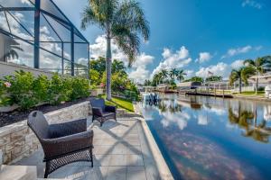 un canale con panchine e palme accanto a un edificio di Villa Blue Pavilion - Heated Pool - Sleeps 16 - Roelens Vacations a Cape Coral
