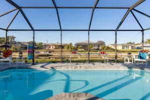 uma piscina com vista para uma casa em Villa Doc Life - Roelens Vacations - Beautiful 3 bedroom, 2 bath Pool home on a gulf access canal em Cape Coral