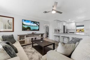 uma sala de estar com um sofá e uma mesa em Villa Doc Life - Roelens Vacations - Beautiful 3 bedroom, 2 bath Pool home on a gulf access canal em Cape Coral