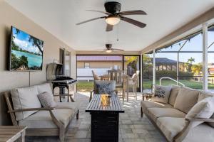 uma sala de estar com um sofá e um piano em Villa Doc Life - Roelens Vacations - Beautiful 3 bedroom, 2 bath Pool home on a gulf access canal em Cape Coral