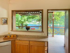 a kitchen with a large window with a view of the water at Palm Bay in Deshaies