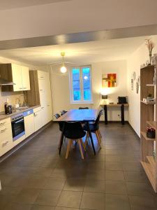 una cocina con mesa y sillas. en Duplex moderne à 10 minutes de Colmar, en Wintzenheim