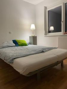 ein Bett mit einem grünen Kissen und einem Fenster in der Unterkunft modern and comfortable apartment next to vienna mainstation in Wien