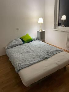 Bett in einem weißen Zimmer mit einem grünen Kissen in der Unterkunft modern and comfortable apartment next to vienna mainstation in Wien