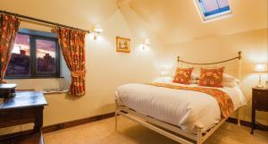 Schlafzimmer mit einem Bett, einem Schreibtisch und einem Fenster in der Unterkunft Waterwheel Guesthouse in Ambleside