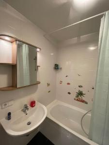 ein weißes Badezimmer mit einem Waschbecken und einer Badewanne in der Unterkunft modern and comfortable apartment next to vienna mainstation in Wien