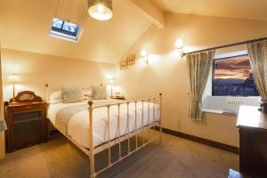 Schlafzimmer mit einem Bett und einem Fenster in der Unterkunft Waterwheel Guesthouse in Ambleside