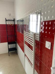 uma casa de banho com paredes vermelhas e brancas e um espelho em Séjour confortable et agréable pour la famille... em Étampes