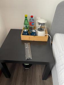 uma mesa preta com bebidas ao lado de uma cama em Séjour confortable et agréable pour la famille... em Étampes