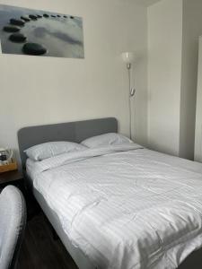 uma cama num quarto com um quadro na parede em Séjour confortable et agréable pour la famille... em Étampes