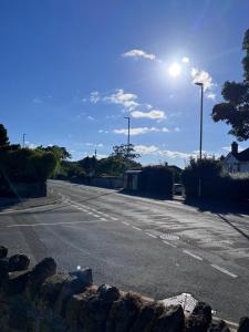 an empty street with the sun in the sky at Two-bedroom Apartment in Yeovil