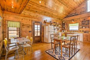 uma cozinha e sala de jantar com mesas e cadeiras em Greenfield Cabin with Screened-In Porch and Fire Pit! em Greenfield